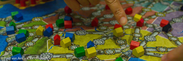 Menschen, die ein Brettspiel mit bunten Steinen spielen