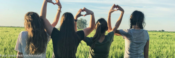 Jugendliche formen ihre Hände zu Herzen